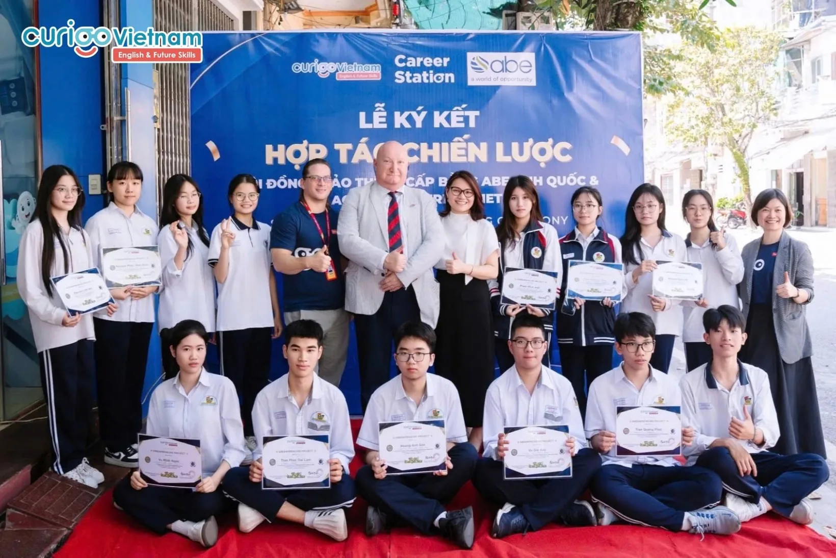 Học sinh cầm giấy chứng nhận chụp ảnh cùng đại diện ABE Anh Quốc và CVN